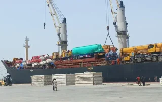 Heavy-duty port cranes loading commercial shipping containers onto a vessel at Gwadar Port.
